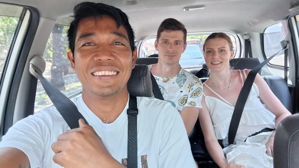Guests smiling in the back seat of a Bali Voyager car
